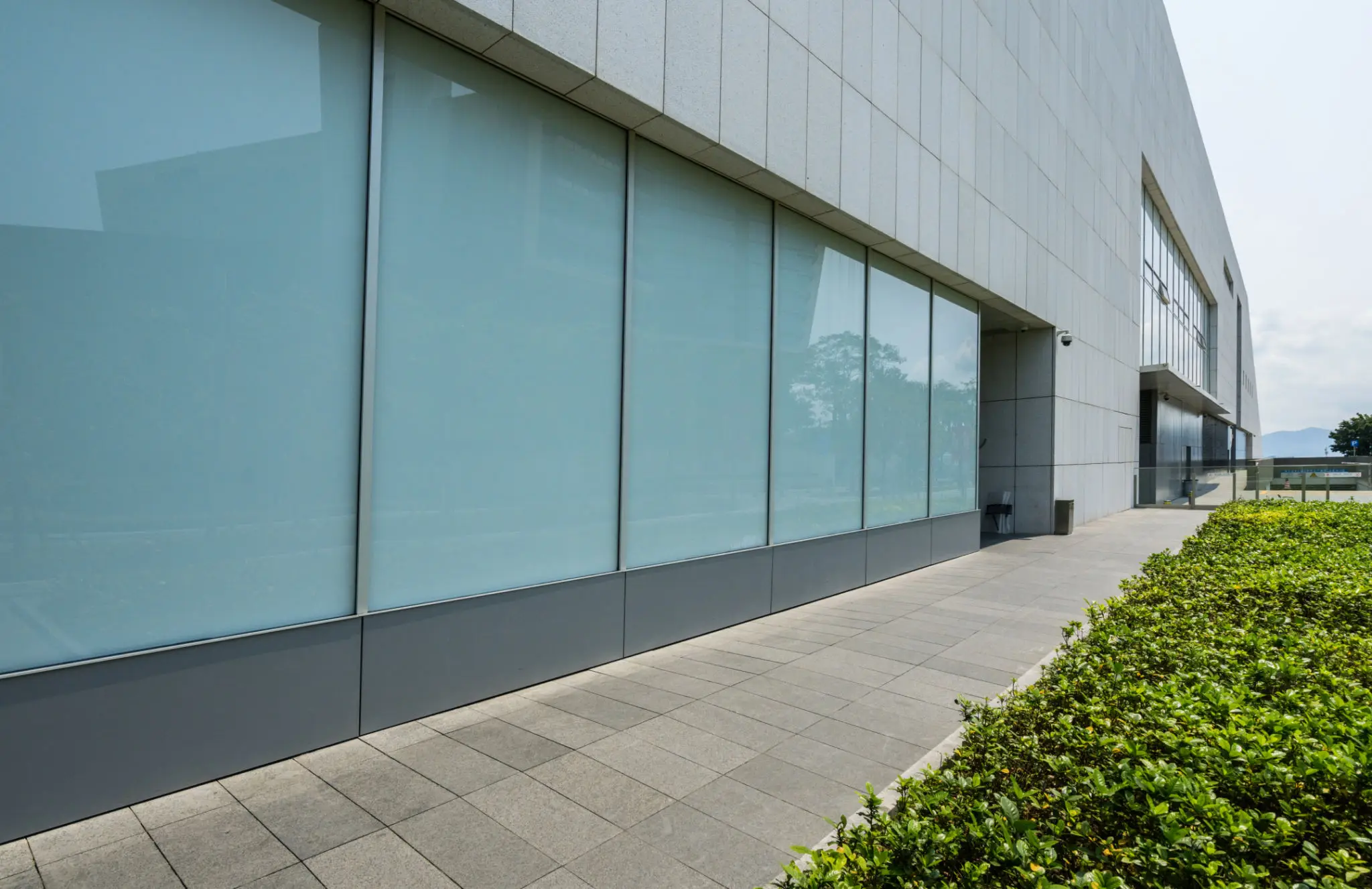 Modern building with large windows and walkway.