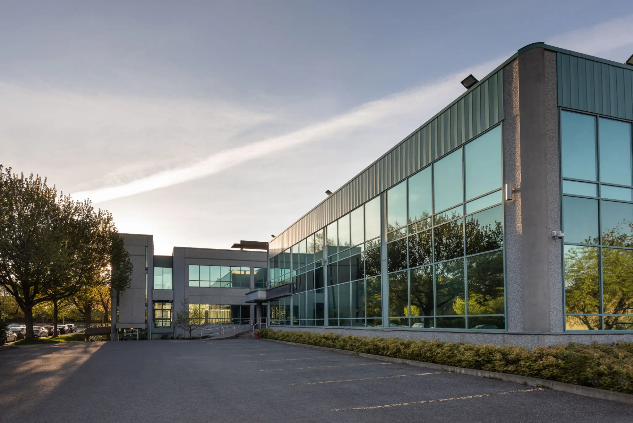 Modern glass office building with trees outside.